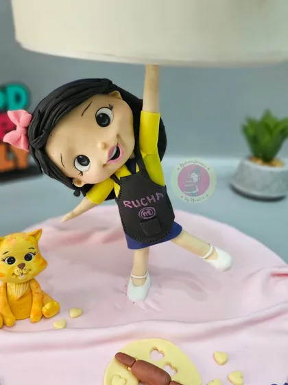 The little baker figurine in action, holding up the cake with a smile. It’s all about capturing that playful spirit.