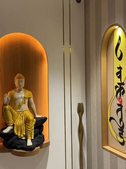 A closer look at the illuminated niche with the Buddha statue. The combination of the warm wood, soft lighting, and the spiritual calligraphy art creates a corner that is perfect for quiet reflection.