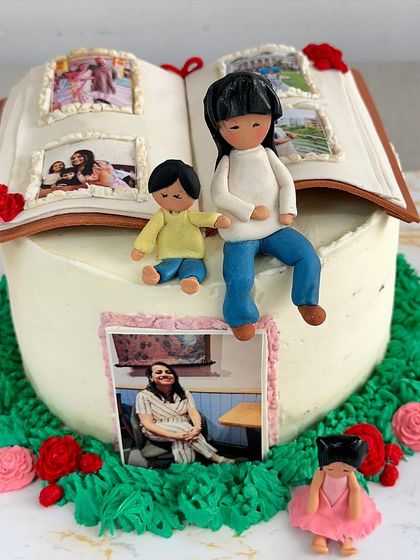 This angle shows the full scope of the storybook cake, with the open book on top and the family figures creating a beautiful, personal narrative.