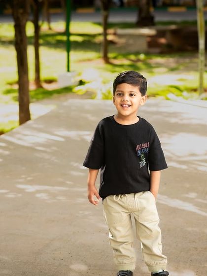 A relaxed and happy portrait of a boy during an outdoor photoshoot. The natural light and casual pose create a timeless and authentic image.