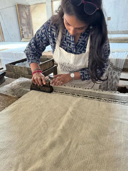 A close-up of me carefully printing a border on a rug using the Dabu technique. Precision is key to ensure the pattern is continuous and even across the fabric.
