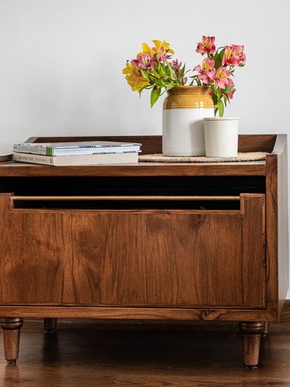 The Makam Bedside Table is a simple yet elegant piece with subtly turned ornate legs and a brass rod that serves as a handle. It is available in customizable sizes to perfectly fit your bedroom space.