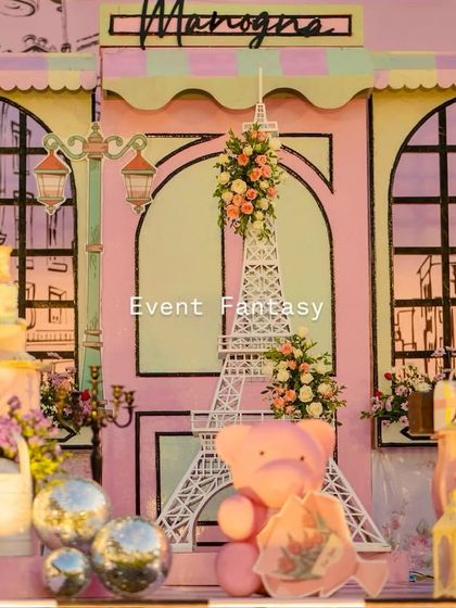 A chic Parisian backdrop with an Eiffel Tower prop and a pink teddy bear.