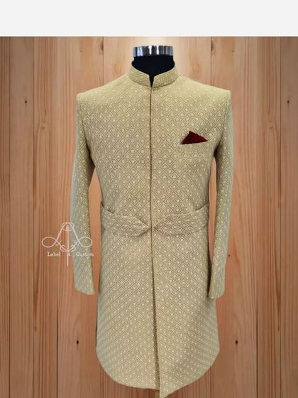 A touch of royalty from my "Royal Collection". This beige sherwani features a unique belted design and a subtle texture, offering a contemporary twist on a traditional garment.
