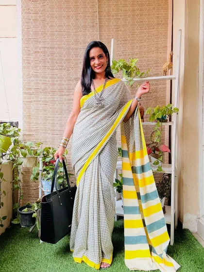 This grey and white checkered saree with a contrasting yellow and blue striped pallu is a fun and playful design. It's a great casual wear saree.