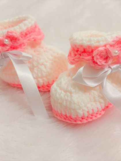 These pink and white booties are so sweet, with a pink fold-over cuff, a delicate rose, and a white satin ribbon.