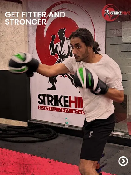 A student works on his boxing technique in front of our brand wall. This image showcases the focus and determination we instill in every member of the StrikeHive family.