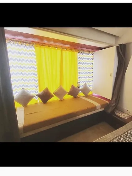 A cozy window seating area, or 'diwan', with built-in storage underneath. This custom piece creates a perfect reading nook while making use of otherwise unused space.
