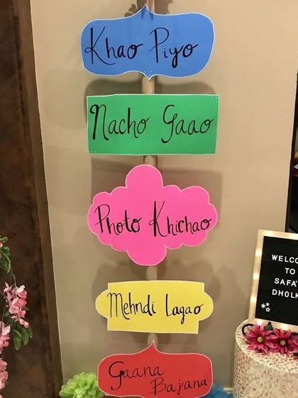 Fun and quirky signage for a Dholki night, with prompts like 'Khao Piyo', 'Nacho Gao', and 'Photo Khichao' to get the party started.