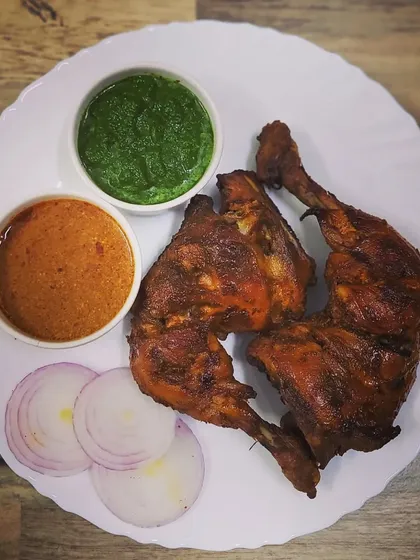 My homemade Tandoori Chicken, made without any artificial food colors. The chicken is marinated in yogurt and a special blend of tandoori spices, then cooked to perfection. It's served with fresh green chutney and a spicy gravy.