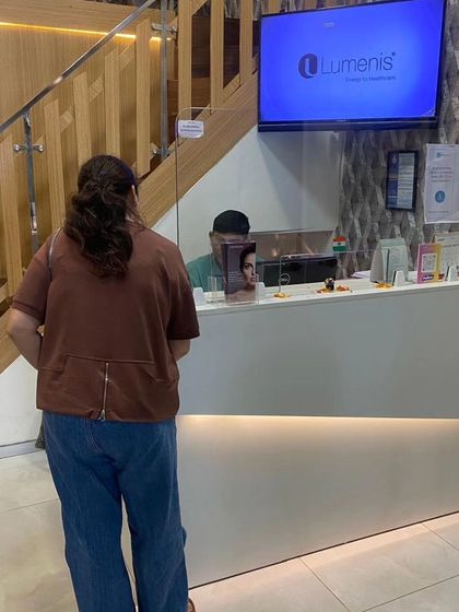 A client at our reception desk. We aim to be a place where all your anxieties are put to rest, providing comprehensive cosmetic care under expert guidance.