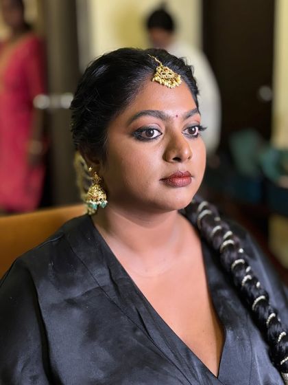 Getting ready for the big moment. A candid shot of Dr. Preetha's muhurtham look, featuring smokey gold eyes and a coral red lip that beautifully complements her skin tone.