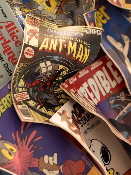 Another detail of "Comic Confluence," featuring covers of Ant-Man, Snoopy, and other nostalgic characters from the world of comics.