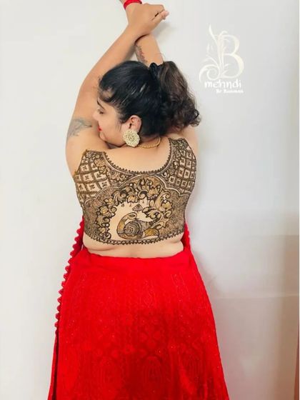 A playful pose showing off the creative back henna. This design is perfect for anyone who wants to make a statement and showcase their love for henna in a new way.