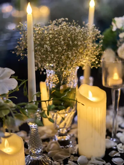 The romantic glow of candles is a key element in my designs. Here, they are scattered among baby's breath and crystal vases.