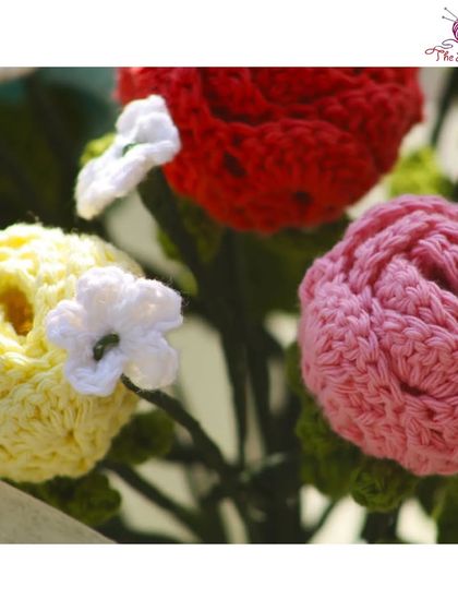 A close-up of the beautiful, textured roses in a handmade bouquet, featuring yellow, pink, and red blooms.