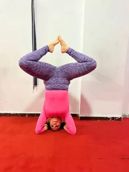A variation of headstand with legs in Baddha Konasana (Bound Angle Pose). This challenges balance and opens the hips while inverted.