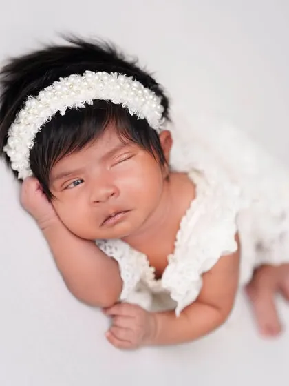 This little one with amazing hair is giving a cute wink. I love capturing these quirky and unexpected expressions that show off their personality.