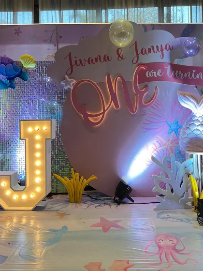For Jivana and Janya's first birthday, we created another enchanting under-the-sea world, featuring marquee letters, iridescent backdrops, and a soft play area for the tiniest guests.
