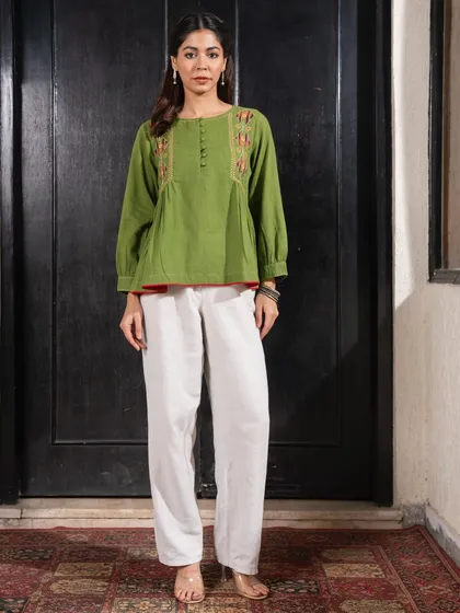 This Paheli green top, paired with white pants, offers a comfortable and stylish look. The hand embroidery and relaxed fit make it a versatile piece for mixing and matching.
