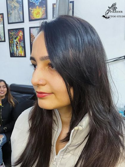 A profile shot of a client with a delicate and subtle nose stud, showing how it complements her features.