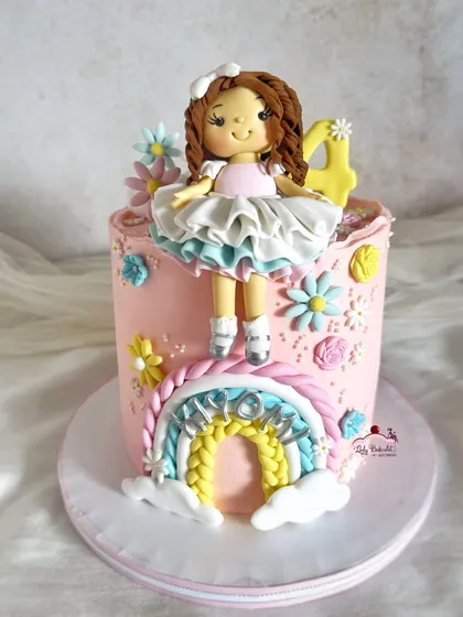 A different angle of this adorable doll and rainbow cake.
