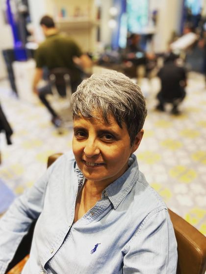 A happy client showing off her fresh pixie cut. The texture on top gives it a playful feel, while the tapered sides keep it neat.