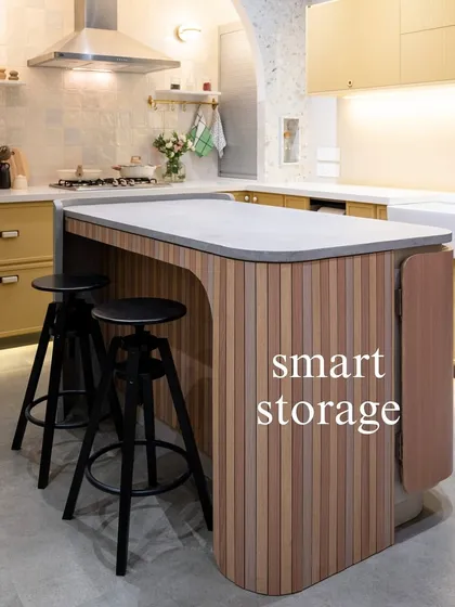 This kitchen island features a clever, extendable counter, perfect for creating extra dining space when needed. The fluted wood detail adds texture and warmth to the modern design.