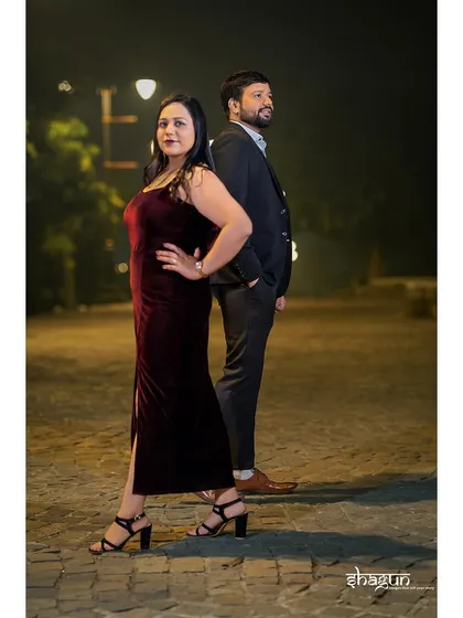 A stylish, back-to-back pose on a cobblestone path at night. This shot has a modern, chic vibe, perfect for the fashionable couple.
