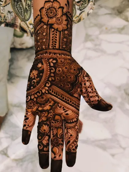 A beautiful, full-hand design with a large floral motif on the wrist. The patterns are a mix of flowers, leaves, and swirls, creating a very organic and flowing look.