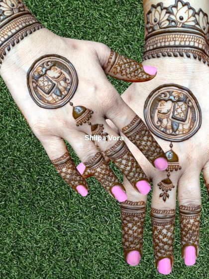 A unique design with elephant mandalas on the back of the hands and 'jhumka' (earring) motifs on the fingers.