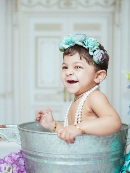 A happy laugh from a baby during his milk bath photoshoot. These sessions are perfect for capturing gummy smiles and cheerful moments.