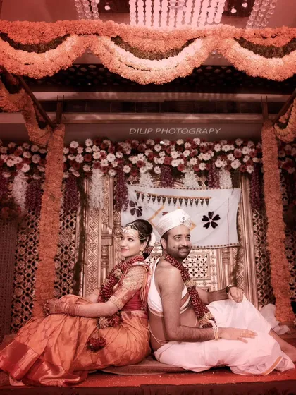 A stunning, artistically lit shot of the couple on their wedding stage. The monochromatic red tone gives this photo a unique and dramatic feel.