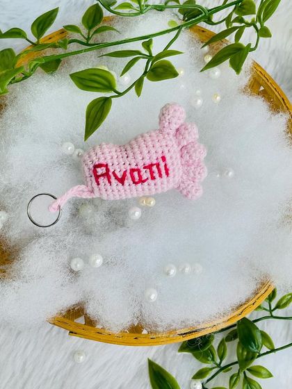 The pink baby foot keychain personalized for 'Avani'.