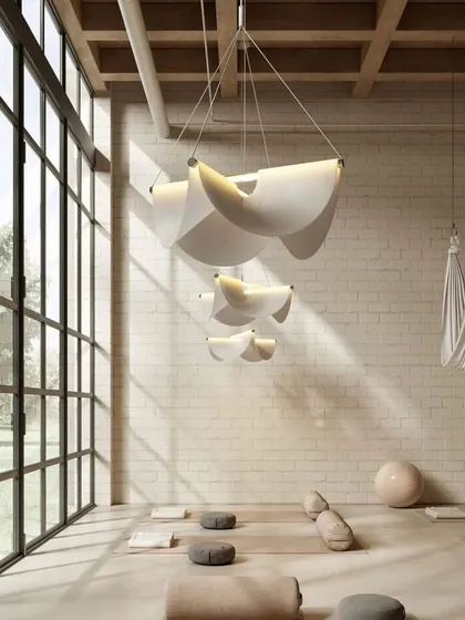 A cluster of Drape Lights in a yoga studio. Their soft, serene forms and warm, downward light contribute to the calm and peaceful atmosphere of the space.