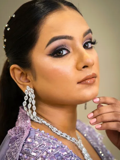A close-up on the eyes and jewellery. This shot highlights the beautiful winged eyeliner and the delicate sparkle of the zircon waterfall earrings, part of a set perfect for a reception.
