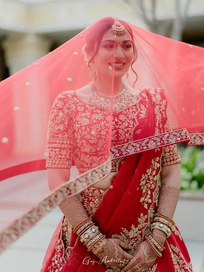 A beautiful shot of the bride with her veil, capturing the movement and the soft light. Her makeup looks flawless and radiant even through the delicate fabric.