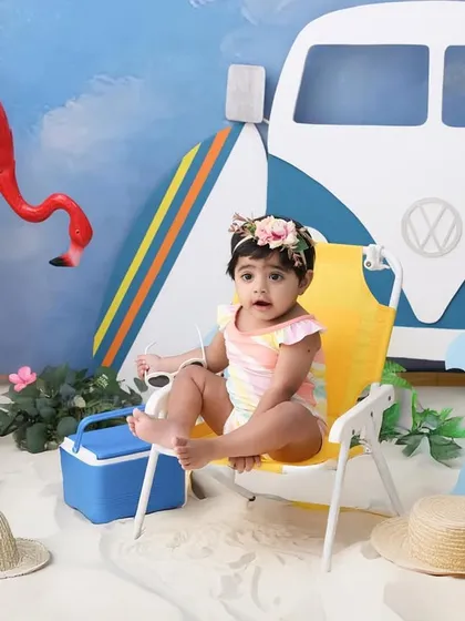Life's a beach. This fun, summery theme brings the beach to my studio. With sand, surfboards, and even flamingos, it's a perfect setup for a playful and unique baby shoot.