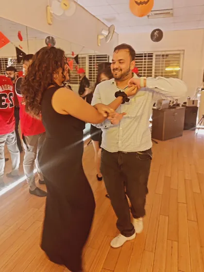 A candid moment of two students dancing at our Halloween studio social. Even with the spooky decor, the vibe is always friendly and fun.