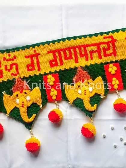 An angled shot of the Ganpati toran, showing the 3D effect of the crocheted elephant faces and the small pearls that add a touch of sparkle.