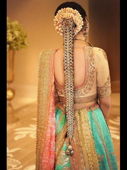 A focus on hair artistry. This stunning, intricate hair accessory worn by Isha perfectly complements her Anuradha Vakil lehenga, showcasing how every detail contributes to the overall look.