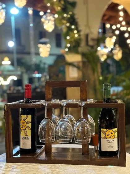 We offer unique ways to serve wine, like this rustic wooden wine rack that holds two bottles and hangs multiple glasses. It's a stylish and practical addition to any bar or dining table.