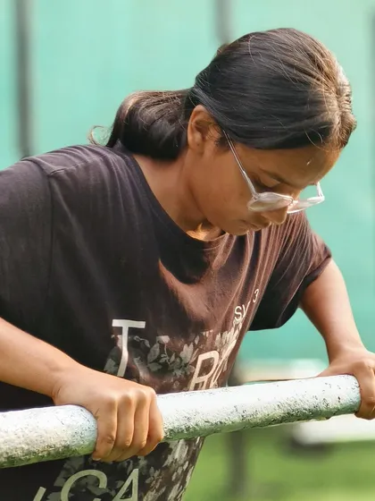 Focused and ready. This young athlete prepares for her next set on the dip bars, building powerful triceps and chest muscles.