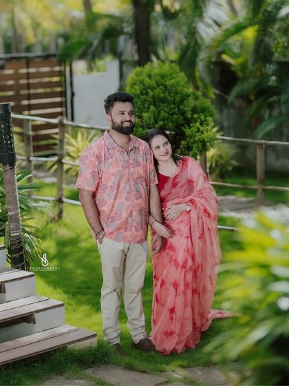 A classic couple portrait in the garden, with her leaning affectionately on his arm.