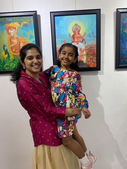 An artist with a young family member enjoying the exhibition, highlighting the community atmosphere.