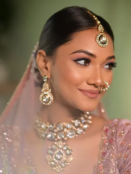 A close-up of this pastel bride's makeup. The winged eyeliner and soft pink tones on the eyes and lips create a look that is both gentle and glamorous.