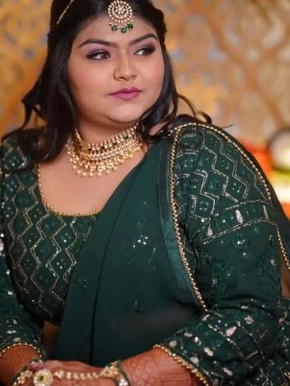 A client looking beautiful for a wedding event in a dark green outfit. She chose a simple but elegant Kundan choker with a matching maang tikka and hathphool.