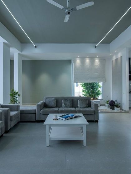 A calm and composed living space designed around a soothing grey palette. The layout is kept simple and functional, with sheer curtains allowing for soft, diffused natural light, creating a perfect atmosphere for relaxation.