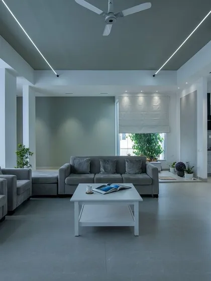 A calm and composed living space designed around a soothing grey palette. The layout is kept simple and functional, with sheer curtains allowing for soft, diffused natural light, creating a perfect atmosphere for relaxation.
