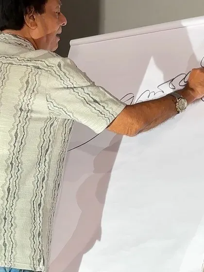 Creating a large-scale signature art piece live on an easel during the Aakhoraghor glorious meet in Guwahati.